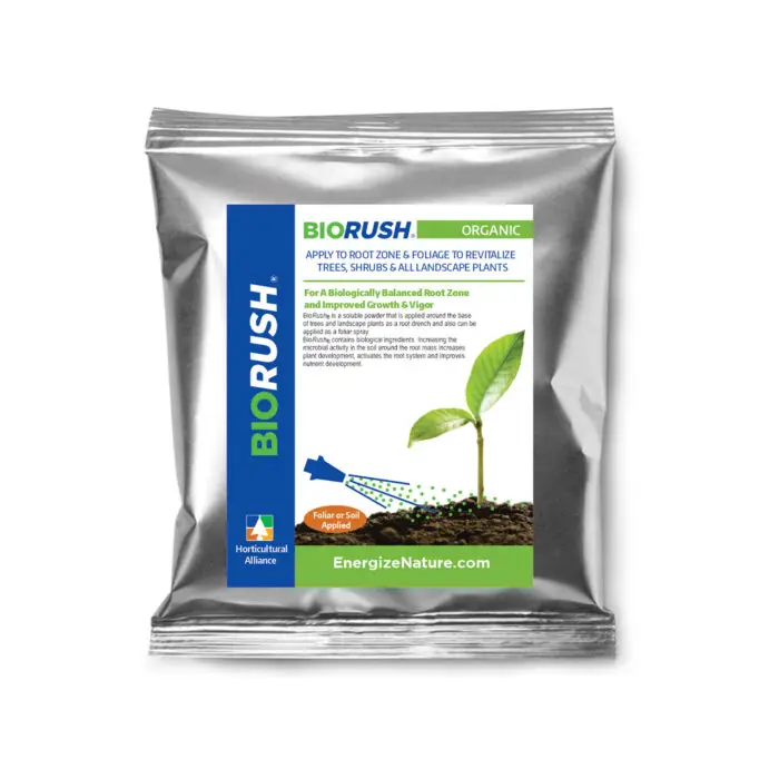 Dry BioRush Organic powder being mixed into a tank sprayer for foliar application, promoting green-up with natural biostimulants and beneficial microbes.